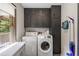 Laundry room with front load washer/dryer units and grey storage cabinets at 3400 Bonds Lake Nw Rd, Conyers, GA 30012