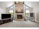 Cozy living room featuring a brick fireplace, a television, and large windows that let in natural light at 3400 Bonds Lake Nw Rd, Conyers, GA 30012
