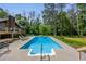 In-ground pool with a charming brick home and deck surrounded by mature trees at 3400 Bonds Lake Nw Rd, Conyers, GA 30012