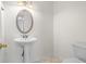 Powder room with a pedestal sink, oval mirror, and tiled floors at 1021 Riverbend Club Se Dr, Atlanta, GA 30339