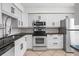 Updated kitchen boasts white cabinets, granite countertops, and stainless steel appliances at 1021 Riverbend Club Se Dr, Atlanta, GA 30339