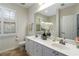 Bright bathroom featuring a double sink vanity, large mirror, and a window with plantation shutters at 2400 Cumberland Se Pkwy # 803, Atlanta, GA 30339