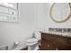 Stylish half bath with a granite countertop vanity, updated fixtures, and a decorative mirror at 3320 Woodleaf Way, Marietta, GA 30062