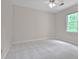 Comfortable bedroom with neutral carpet, a ceiling fan, and a window offering peaceful outdoor views at 3320 Woodleaf Way, Marietta, GA 30062