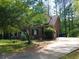 Cozy brick home with mature trees, inviting front lawn, and long driveway at 921 Eagle Crossing Dr, Lawrenceville, GA 30044