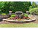 Stone-walled community entrance with colorful flowers and greenery at 2060 Executive Dr, Duluth, GA 30096