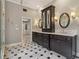 Bathroom featuring black cabinets, a decorative tile floor, and a double vanity with sconces at 3115 Corsair Curv, Cumming, GA 30040