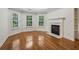 A bedroom with hardwood floors, a fireplace, three windows, and white trim at 3115 Corsair Curv, Cumming, GA 30040