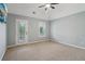 Spacious bedroom with a fan, neutral carpet and large window illuminating the room at 3115 Corsair Curv, Cumming, GA 30040