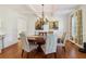 Elegant dining area featuring hardwood flooring, a modern chandelier, and wainscoting at 3115 Corsair Curv, Cumming, GA 30040