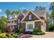 Traditional brick home featuring a well-maintained lawn, manicured landscaping, and attached garage at 3115 Corsair Curv, Cumming, GA 30040