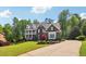 Beautiful brick home featuring a well-manicured lawn, mature trees, and a spacious driveway at 3115 Corsair Curv, Cumming, GA 30040