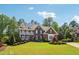 Beautiful brick home with manicured lawn, mature trees, and a charming front porch, offering curb appeal at 3115 Corsair Curv, Cumming, GA 30040