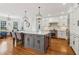Large kitchen with an island, stainless appliances, hardwood floors, and a view to the living area at 3115 Corsair Curv, Cumming, GA 30040