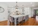 Bright eat-in kitchen featuring an island with a marble countertop, stainless steel appliances, and modern lighting at 3115 Corsair Curv, Cumming, GA 30040