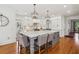 Bright eat-in kitchen with oversized island, stainless appliances, hardwood floors, and designer light fixtures at 3115 Corsair Curv, Cumming, GA 30040
