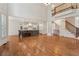 Open-concept living room with hardwood floors, staircase and view into kitchen with pendant lighting and center island at 3115 Corsair Curv, Cumming, GA 30040