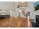Open-concept living room with staircase, fireplace, hardwood floors, and view into kitchen with large center island at 3115 Corsair Curv, Cumming, GA 30040
