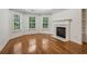 Inviting living room with a cozy fireplace, large windows, and gleaming hardwood floors at 3115 Corsair Curv, Cumming, GA 30040
