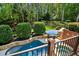 Scenic backyard with pool, spa, and stone accents surrounded by mature trees at 3115 Corsair Curv, Cumming, GA 30040