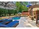Luxurious pool area with sun loungers, spa, stone accents, and manicured landscaping at 3115 Corsair Curv, Cumming, GA 30040