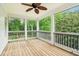 An outdoor porch with wood floors, screens, and a view of the surrounding trees at 3115 Corsair Curv, Cumming, GA 30040