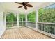 Relaxing screened porch with wood floors, offering a serene outdoor living space overlooking lush greenery at 3115 Corsair Curv, Cumming, GA 30040