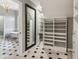 Spacious walk-in closet with custom white shelving and drawers with black and white checkered floors at 3115 Corsair Curv, Cumming, GA 30040