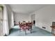 Bright dining room with blue carpet, table with chairs, and white walls and curtains at 5618 Fern Creek Sw Dr, Lilburn, GA 30047