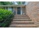 Brick stairs with black railing lead to front door, adorned with wreath, flanked by green bushes at 5618 Fern Creek Sw Dr, Lilburn, GA 30047