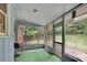 View of the screened porch with green flooring overlooking the backyard with a grill at 5618 Fern Creek Sw Dr, Lilburn, GA 30047