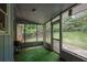 View of the screened porch with green flooring overlooking the backyard at 5618 Fern Creek Sw Dr, Lilburn, GA 30047