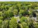 An aerial view shows this home nestled among mature trees in a lush, green neighborhood at 1256 Spring Valley Ne Ln, Atlanta, GA 30306
