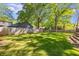 Spacious backyard featuring lush green lawn, a wooden fence, and mature trees, perfect for outdoor activities and privacy at 1256 Spring Valley Ne Ln, Atlanta, GA 30306