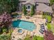 Aerial view of a large backyard with a pool, jacuzzi, stone patio, and outdoor seating area at 2120 Blackheath Trce, Alpharetta, GA 30005