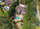 Beautiful backyard with a pool, stone patio, well-manicured landscaping, and mature trees at 2120 Blackheath Trce, Alpharetta, GA 30005