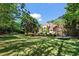 Expansive backyard with lush green lawn, mature trees, and an inviting view of the elegant home and pool area at 2120 Blackheath Trce, Alpharetta, GA 30005