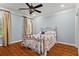 This bedroom features light blue walls, wood floors and a gorgeous metal-frame bed topped with colorful bedding at 2120 Blackheath Trce, Alpharetta, GA 30005
