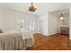 Bright bedroom featuring hardwood floors, neutral walls, plantation shutters, and unique lighting fixtures at 2120 Blackheath Trce, Alpharetta, GA 30005