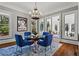Bright dining room featuring a modern chandelier, glass table, and beautiful blue chairs at 2120 Blackheath Trce, Alpharetta, GA 30005