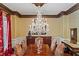 Elegant dining room with hardwood table, cushioned chairs, and a stunning crystal chandelier above at 2120 Blackheath Trce, Alpharetta, GA 30005
