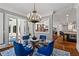 Bright dining room with chandelier, blue chairs, and views to the outdoor living space at 2120 Blackheath Trce, Alpharetta, GA 30005