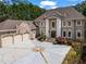 Stately brick home featuring meticulously manicured landscaping and a circular driveway at 2120 Blackheath Trce, Alpharetta, GA 30005