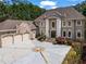 Impressive brick home with a three-car garage, elegant landscaping, and a circular driveway for sophisticated curb appeal at 2120 Blackheath Trce, Alpharetta, GA 30005