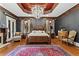 Luxurious main bedroom featuring a tray ceiling, chandelier, and hardwood floors at 2120 Blackheath Trce, Alpharetta, GA 30005