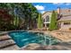 Backyard pool and stone patio surrounded by mature trees at 2120 Blackheath Trce, Alpharetta, GA 30005