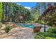 Backyard pool and patio surrounded by lush landscaping, lounge chairs and tables at 2120 Blackheath Trce, Alpharetta, GA 30005