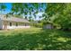 View of the backyard featuring a green lawn, shed, and the back of a light-colored home at 63 Seminole Ne Rd, Cartersville, GA 30121
