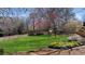 Expansive backyard featuring a lush lawn, wooden fence, and mature trees at 720 Lakeglen Dr, Suwanee, GA 30024