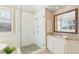 Modern bathroom featuring a glass shower, granite countertops, and a window with shutters at 720 Lakeglen Dr, Suwanee, GA 30024
